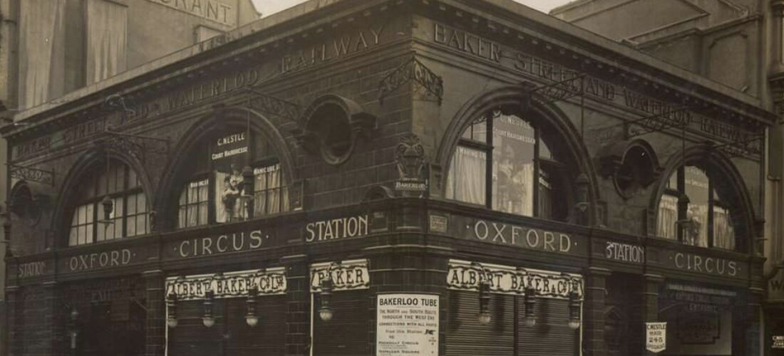 Oxford Circus Station photographed c.1910 with Albert Baker & Co shopfronts and the original Bakerloo tube signage