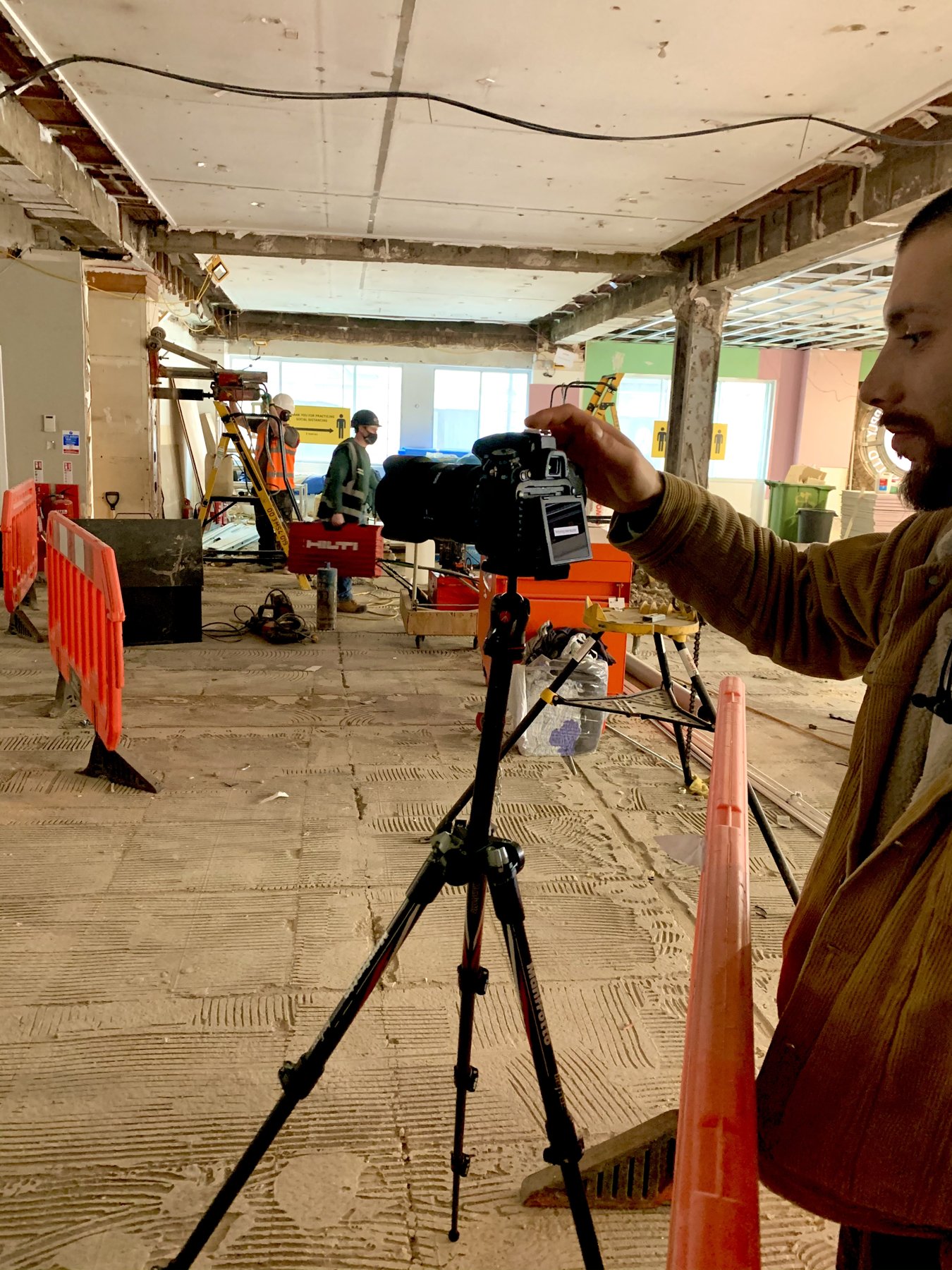 RE FRSH photographer setting up a tripod camera in a pre-fit-out commercial space